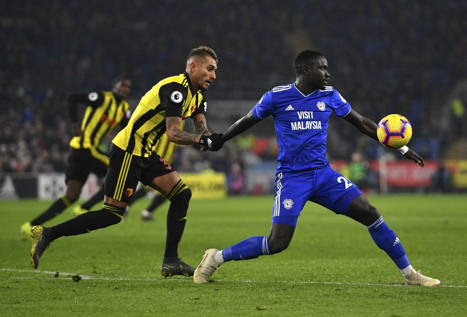 Watford's Roberto Pereyra (left) pulls Cardiff City's Oumar Niasse during the English Premier League soccer match between Cardiff City and Watford at the Cardiff City Stadium, Wales on Friday.