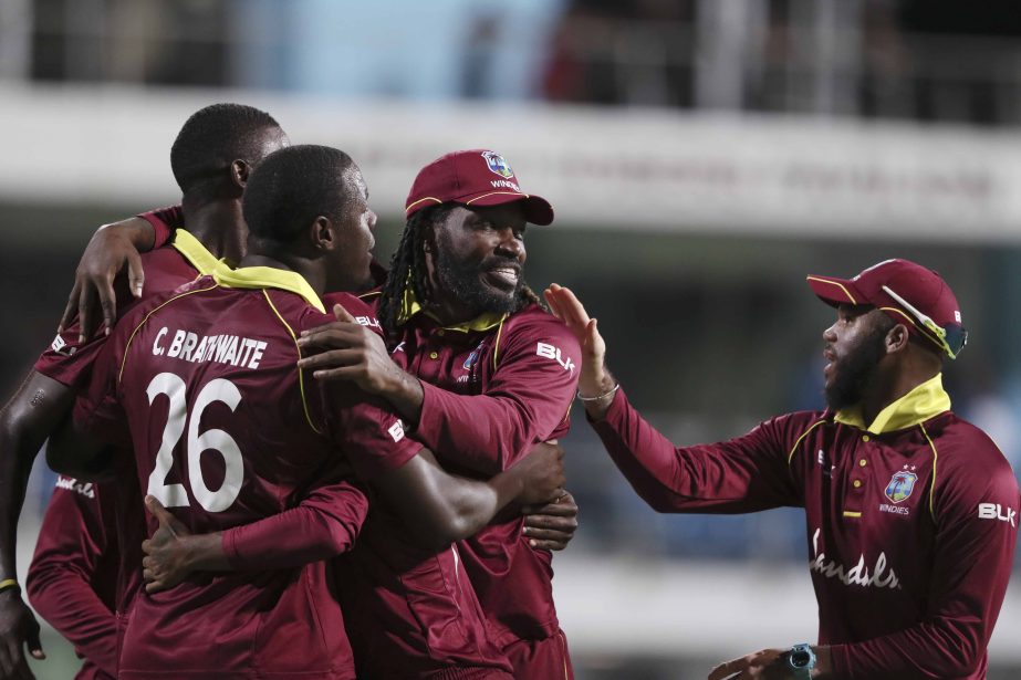 West Indies' Chris Gayle (second from right) and teammates celebrate beating England by 26 runs on the second One Day International cricket match at the Kensington Oval in Bridgetown, Barbados on Friday.