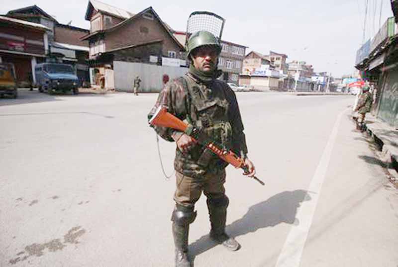 Indian Central Reserve Police Force (CRPF) personnel stand guard in front of closed shops during restrictions after Kashmiri separatist called for shutdown to protest the arrest of their leaders in Srinagar on Sunday.