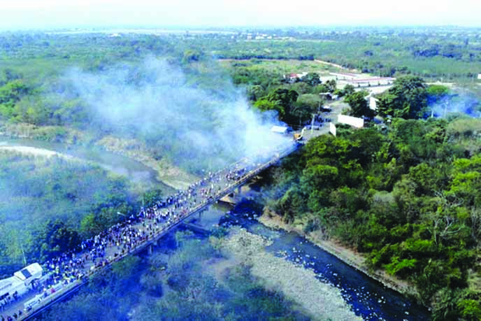 An aerial picture shows smoke billowing from trucks which were carrying humanitarian aid and set ablaze on the Francisco de Paula Santander International Bridge between Cucuta in Colombia and Urena in Venezuela.