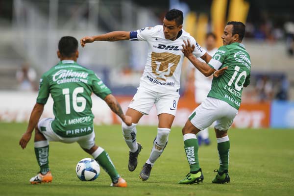 Puma's Pablo Barrera (center) tries to move the ball past Leon's Jean Meneses (left) and Luis Montes during a Mexico soccer league match in Mexico City on Sunday. Leon won 3-1 .