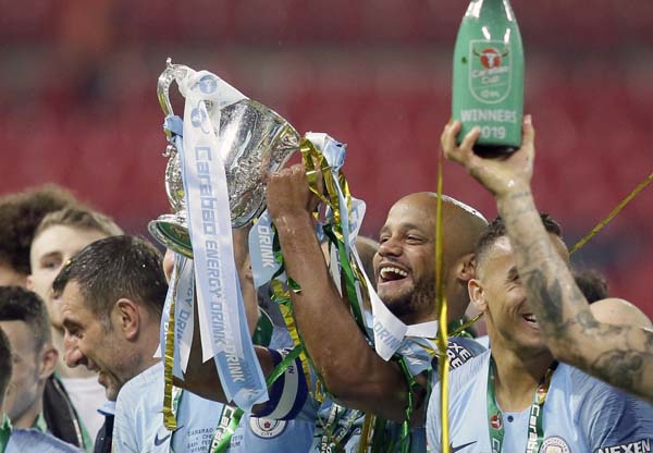 Manchester City's Vincent Kompany lifts the trophy after winning the English League Cup Final soccer match between Chelsea and Manchester City at Wembley stadium in London, England on Sunday.