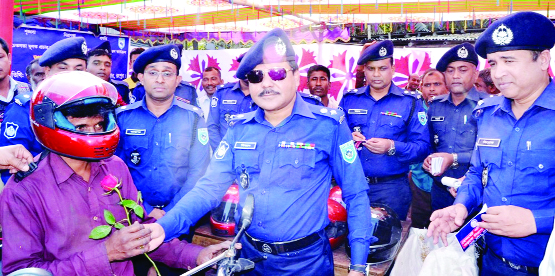 RANGPUR: Superintending of Police Mizanur Rahman greeting helmet -wearing motor-cycle drivers with flowers at an awareness raising programme on traffic rules held at Shothbari area in Mithapukur Upazila on Monday .