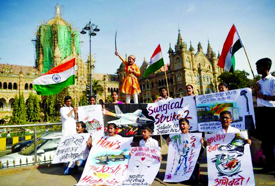 Indians hold placards and national flags as they celebrate the Indian Air Force (IAF) strike launched on a Jaish-e-Mohammad (JeM) camp at Balakot, in front of the Chattrapathi Shivaji Terminus (CST) railway station in Mumbai on Tuesday.