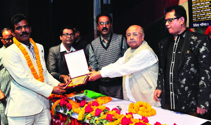 Advisory Council Member of Awami League Mozaffar Hossain Paltu presenting citation crest to politician and businessmen Mohammad Israfil at a reception and discussion on 'International Mother Language Day and Bangabandhu' organised by Dhaka Sangeet Acad