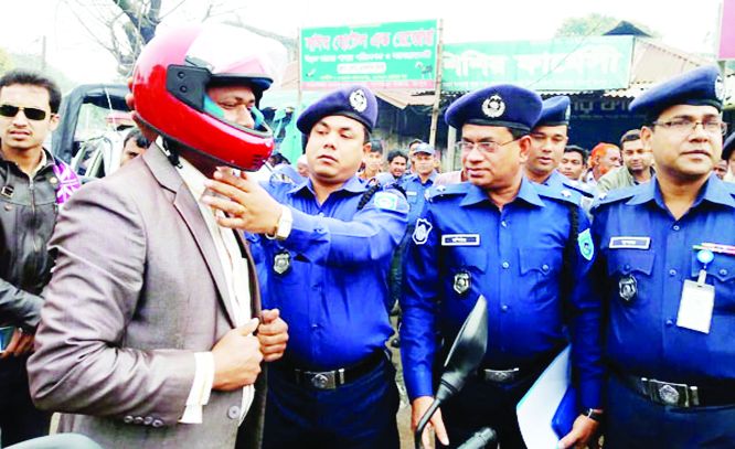 GANGACHARA (Rangpur ): Additional Police Super Saifur Rahman distributing helmets among the motorcycle drivers to prevent road accident yesterday .