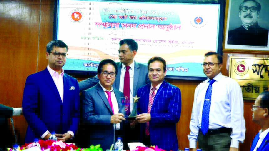 Md Humayun Kabir, Executive Director of Walton Group, receiving the crest of the second highest VAT payer at DITF-2019 from NBR Chairman Md Mosharraf Hossain Bhuiyan at a function in the city recently.