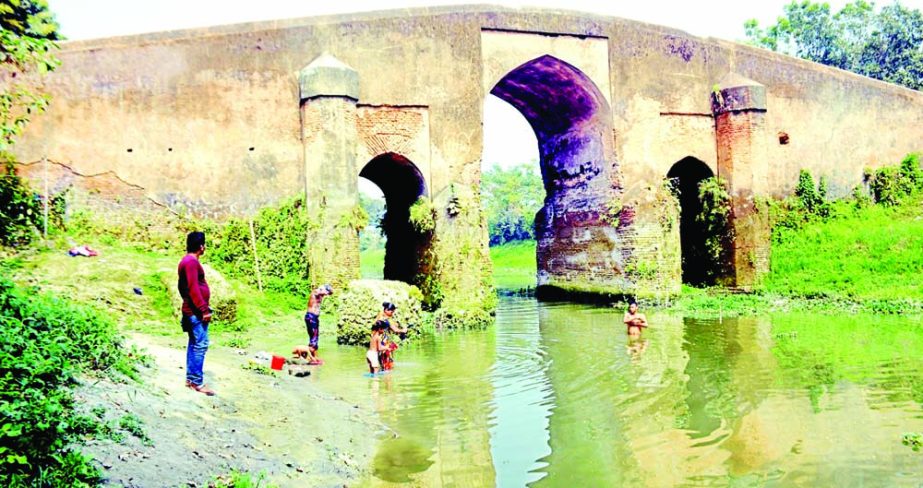 MUNSHIGANJ : An ancient bridge over Tongibari canal at Tongibari in Munshiganj needs immediate repair . Photo : Banglar Chok