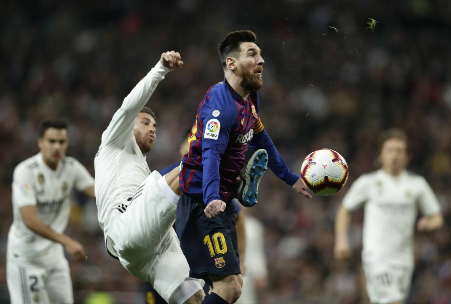 Barcelona forward Lionel Messi (right) is challenged by Real defender Sergio Ramos during the Spanish La Liga soccer match between Real Madrid and FC Barcelona at the Bernabeu stadium in Madrid on Saturday.