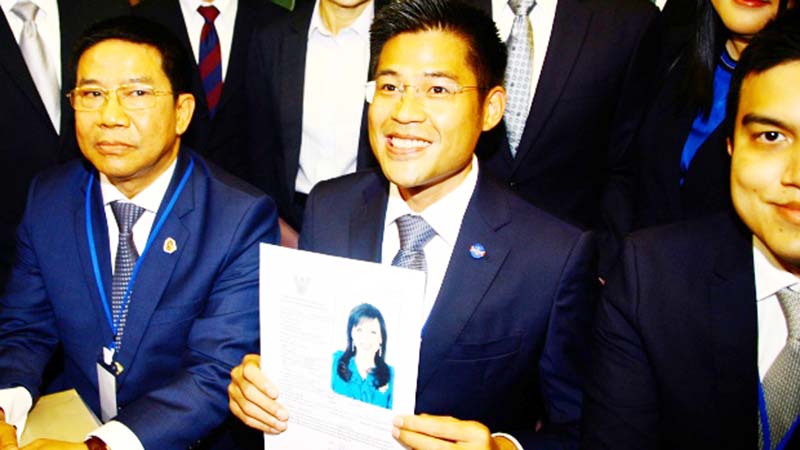 Leader of Thai Raksa Chart party Preecha Pholphongpanich, center, holds a picture of Princess Ubolratana at election commission of Thailand in Bangkok, Thailand on Thursday