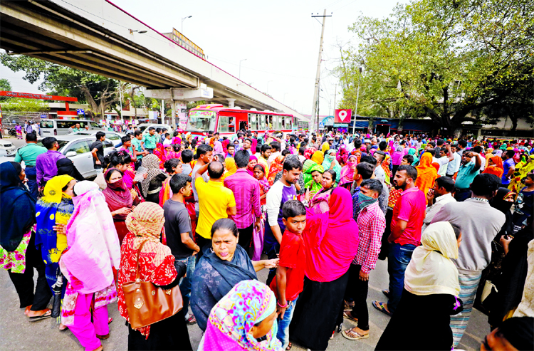 Several hundred RMG workers put up barricade on the busy street in Tejgaon's Saat Rasta demanding for wage hike on Thursday.