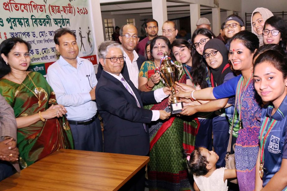 Vice-Chancellor of Dhaka University Professor Dr Md Akhtaruzzaman handing over the trophy to the members of Rokeya Hall, the champions of the Inter-Hall Volleyball Competition for female students of DU at the Central Playground of DU on Thursday.