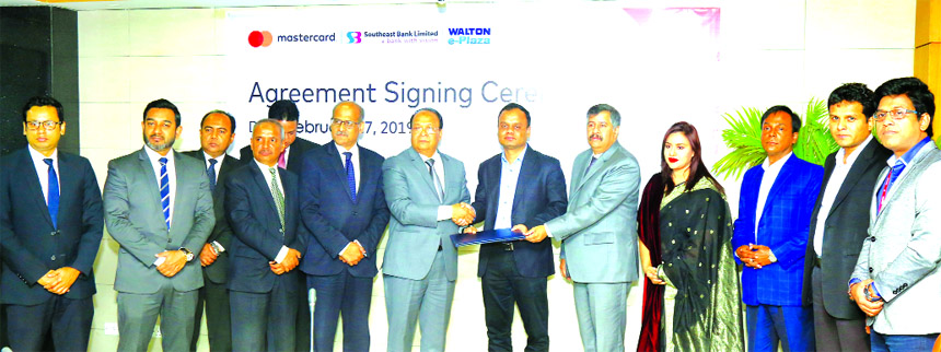 M Kamal Hossain, Managing Director of Southeast Bank Limited and Tanvir Rahman, Executive Director (Supply Chain Management) of Walton Group, exchanging an agreement signing document for online shopping of Walton products at the Bank's head office in the