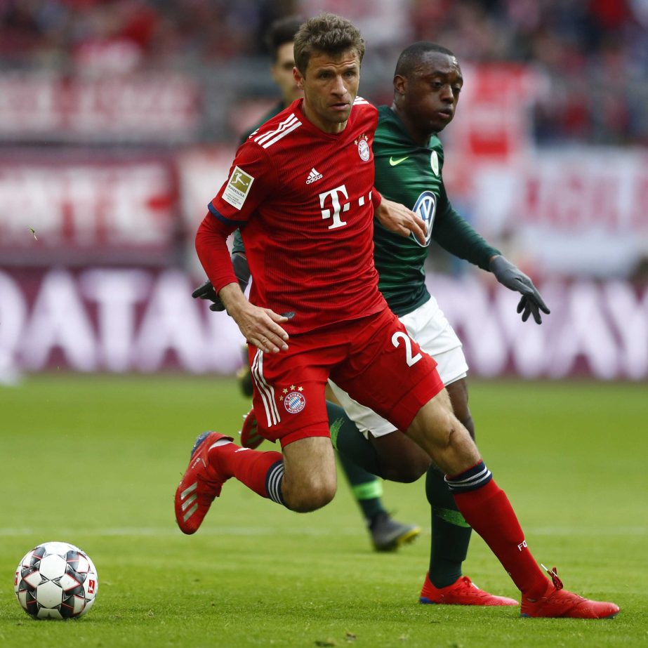 Bayern's Thomas Mueller (left) and Wolfsburg's Jerome Roussillon challenge for the ball during the German Bundesliga soccer match between FC Bayern Munich and VfL Wolfsburg in Munich, Germany on Saturday.