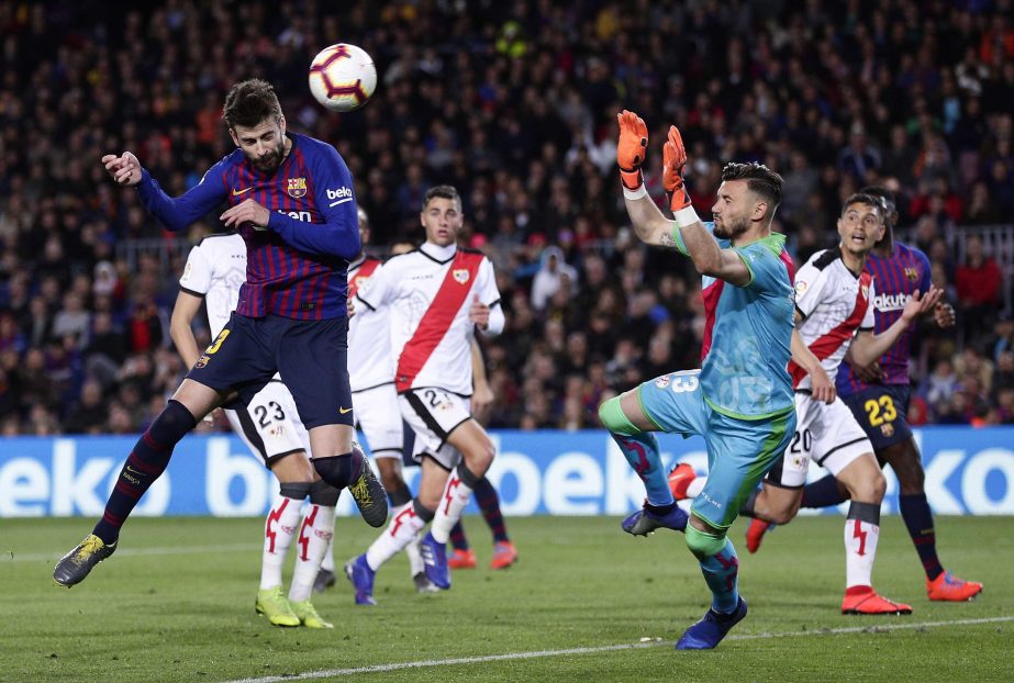 FC Barcelona's Gerard Pique (left) heads for the ball to score his side's first goal during the Spanish La Liga soccer match between FC Barcelona and Rayo Vallecano at the Camp Nou stadium in Barcelona, Spain on Saturday.