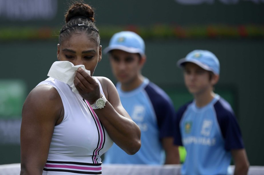 Serena Williams leaves the court, retiring with a medical issue, during her match against Garbine Muguruza of Spain at the BNP Paribas Open tennis tournament on Sunday.