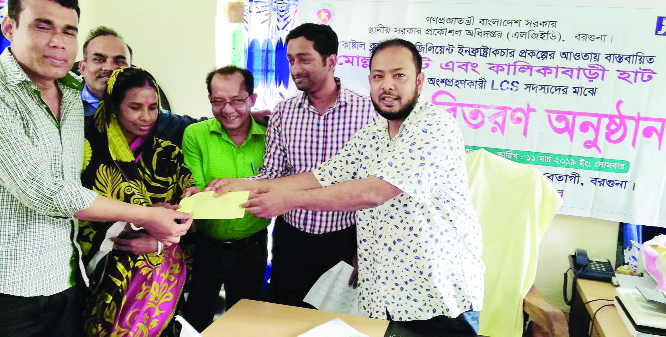 BETAGI (Barguna): Women workers receiving benefit's cheques of LCS under Coastal Climate Resilient Infrastructure(CCRIP) Project at Mollar Hat in Betagi Upazila on Monday. Among others, Md Rajib Ahsan, UNO and Mahbubul Alam Sujon, Chairman, Mokamia U