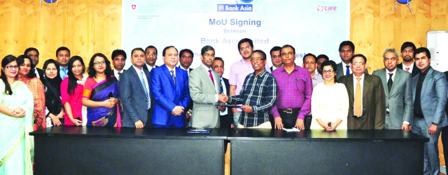 Md. Arfan Ali, Managing Director of Bank Asia Limited and Berhanu Moreda, Assistant Country Director of CARE Bangladesh, exchanging a MoU signing document for "Strengthening access to formal financial services for poor and smallholder farmers including t