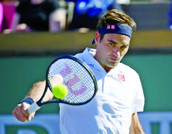 Roger Federer of Switzerland, hits a backhand to Kyle Edmund of Britain, at the BNP Paribas Open tennis tournament in Indian Wells, Calif on Wednesday.