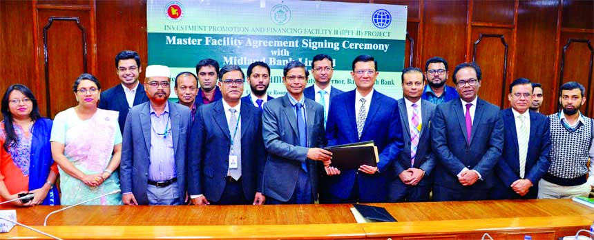 Ahmed Jamal, Deputy Governor of Bangladesh Bank (BB) & Project Director of IPFF II and Md. Ahsan-uz Zaman, CEO of Midland Bank Limited, exchanging an agreement signing document for Investment Promotion and Financing Facility II (IPFF II) project at BB hea