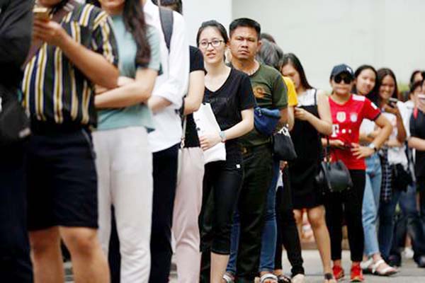 People line up for their early vote of the upcoming Thai election at a polling station in Bangkok, Thailand on Sunday.