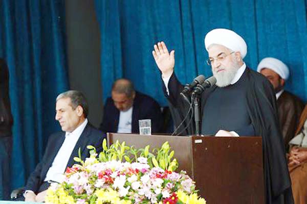Iranian President Hassan Rouhani gestures to the crowd at a public speech in Bandar Kangan, Iran on Sunday.