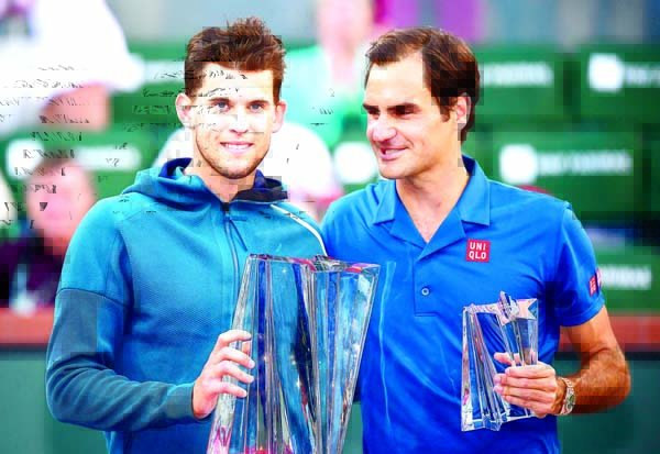 Dominic Thiem, of Austria (left) and Roger Federer, of Switzerland, pose with trophies after Thiem defeated Federer in the men's final at the BNP Paribas Open tennis tournament in Indian Wells Calif on Sunday.