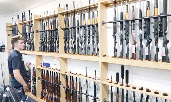 A man looks at firearms on display at Gun City gunshop in Christchurch, New Zealand on Tuesday.