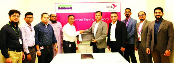 Mizanur Rashid, Chief Commercial Officer of bKash Limited and Syed Ashraful Islam, Chief Financial Officer of Asrotex Group, exchanging an agreement signing document at bKash head office in the city recently. Under the deal, around 17 thousand RMG workers