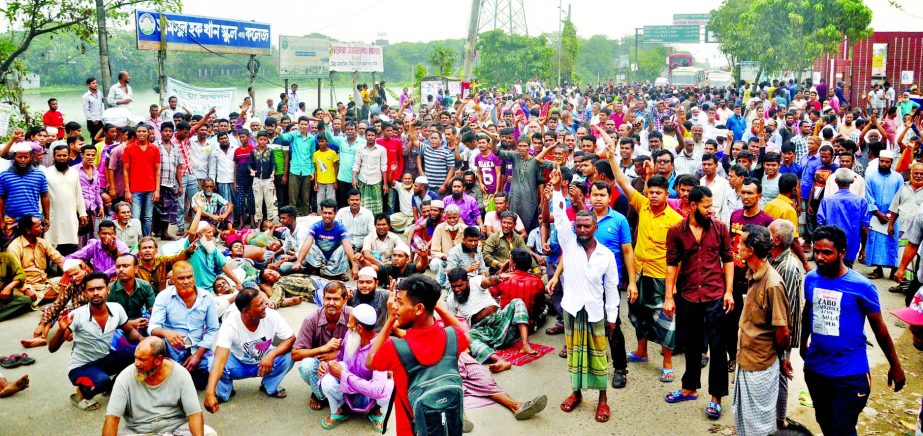 Workers and employees of Latif Bawani Jute Mills and Karim Jute Mills put barricade on road in front of Sultana Kamal Bridge demanding to implement pay structure announced by Wage Commission from 1st July 2015.