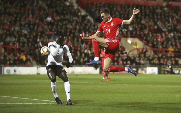 Trinidad and Tobago's Aubrey David (left) and Wales' Ryan Hedges battle for the ball during the International Friendly soccer match between Wales and Trinidad and Tobago, at the Racecourse Ground, in Wrexham, Wales on Wednesday.