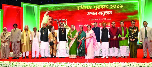 Prime Minister Sheikh Hasina seen at the photo session with the recipients of Independence and National Day Award at the Bangabandhu International Conference Centre on Monday.