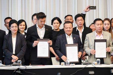 Sudarat Keyuraphan, Pheu Thai Party's prime ministerial candidate (L), Thanathorn Juangroongruangkit, leader of the Future Forward Party (2L), and leaders of other parties hold up agreements during a news conference to form a "democratic fron