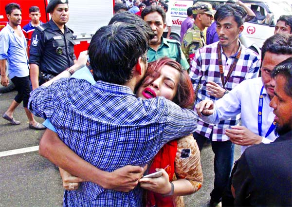 A youth and a tender age girl hugging each other after escaping the Banani inferno thrust on Thursday in Dhaka city.