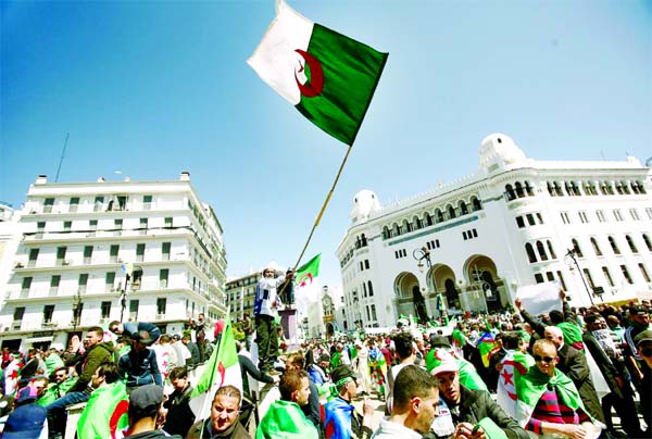 People carry national flags during a protest to demand the removal of President Abdelaziz Bouteflika in Algiers, Algeria.