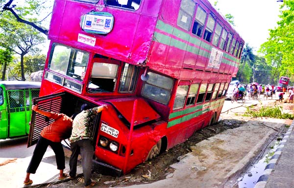 A BRTC double-decker bus plunges into a roadside ditch near Central Shaheed Minar on Monday when the driver tried to overtake other vehicles on the road.