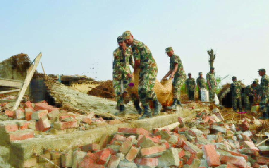 Nepali soldiers carry out belongings from a damaged home in Nepal's southern Bara district near Birgunj on 1 April 2019, the morning after a rare spring storm.