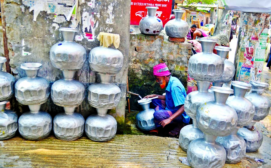 As summer looms on the horizon, shortage of safe drinking water has gripped parts of the capital forcing people line up with pitchers to collect water from open water pipes of Dhaka Water Supply and Sewerage Authority (DWASA). Photo shows an old man helps