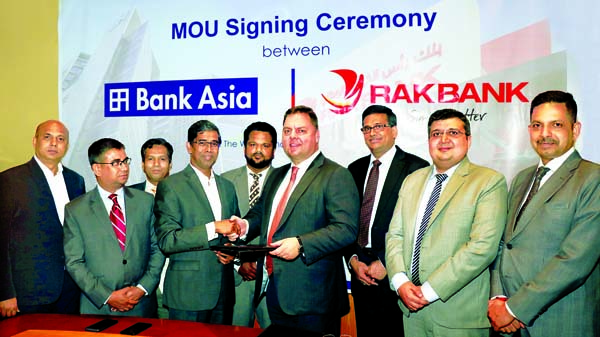 Md. Arfan Ali, Managing Director of Bank Asia Limited and Jean Pieree Le Roux, Managing Director of RAKBANK, UAE, exchanging a MoU signing document to accelerate foreign trade and remittance services for customers at a hotel in the city recently. SM Iqbal