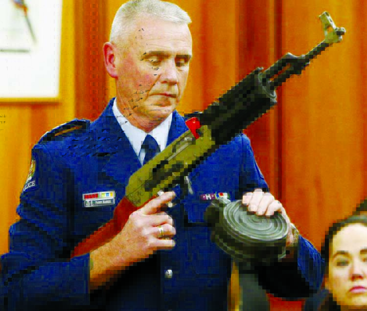 Police Sr Sgt Paddy Hannan shows New Zealand lawmakers in Wellington Tuesday an AR-15 style rifle similar to one of the weapons a gunman used to kill 50 people at two mosques. Photo: AP