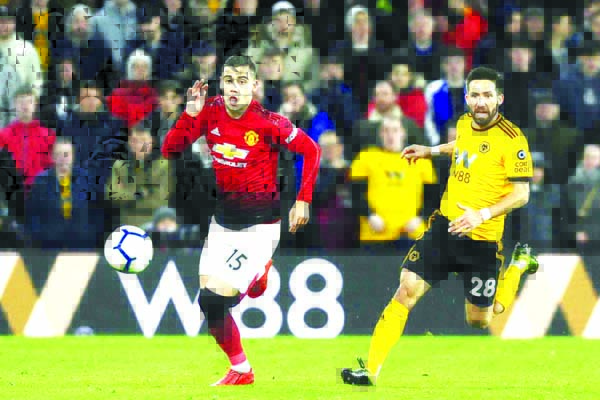 Manchester United's Andreas Pereira and Wolverhampton's Joao Moutinho (right) run for the ball during the English Premier League soccer match between Wolverhampton Wanderers and Manchester United at the Molineux Stadium in Wolverhampton, England on Tue