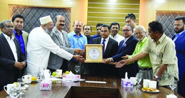 The officials of Mohammedan Sporting Club giving away a crest of honour to AHM Mustafa Kamal, Minister for Finance, at his office in the city's Sher-e-Bangla Nagar on Tuesday.