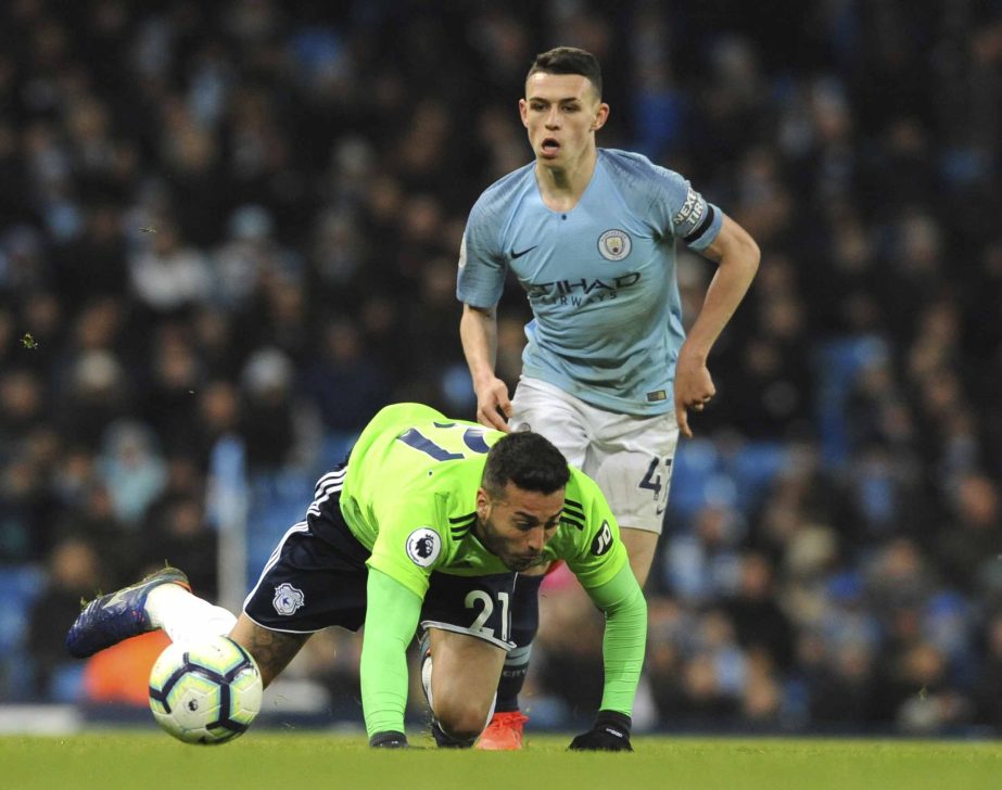 Cardiff's Victor Camarasa (left) and Manchester City's Phil Foden challenge for the ball during the English Premier League soccer match between Manchester City and Cardiff City at Etihad stadium in Manchester, England on Wednesday.
