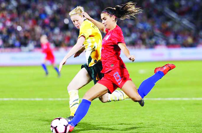 Alex Morgan (right) of United States, shoots as Clare Polkinghorne of Australia, defends during the second half of an international friendly football of women between US and Australia in Colorado on Thursday. US won the match 5-3.