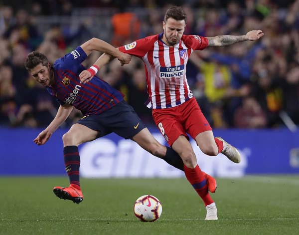 Atletico midfielder Saul Niguez (right) and Barcelona midfielder Sergi Roberto (left) vie for the ball during a Spanish La Liga soccer match between FC Barcelona and Atletico Madrid at the Camp Nou stadium in Barcelona, Spain on Saturday.