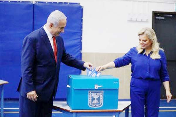Israel's Prime Minister Benjamin Netanyahu casts his vote with his wife Sara during Israel's parliamentary election in Jerusalem on Tuesday.