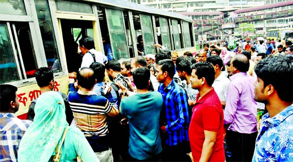 People rush to board a rare bus stretching from Mirpur Section-12 to Mirpur Section-10 Chattar due to Metro rail construction work and also road digging problem, causing sufferings to common people and office goers. This photo was taken on Wednesday.