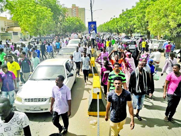 Sudanese protesters march towards the military headquarters as an army statement is awaited.