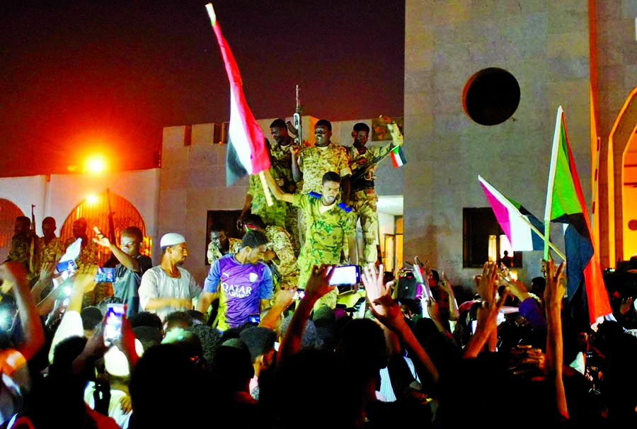 Sudanese military join demonstrators to celebrate after the Defence Minister Awad Ibn Auf stepped down as head of the country's transitional ruling military council, as protesters demanded quicker political change, outside the Defence Ministry in Khartou