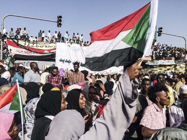 Sudanese demonstrators march with national flags as they gather during a rally demanding a civilian body to lead the transition to democracy, outside the army headquarters in the Sudanese capital Khartoum on Saturday.